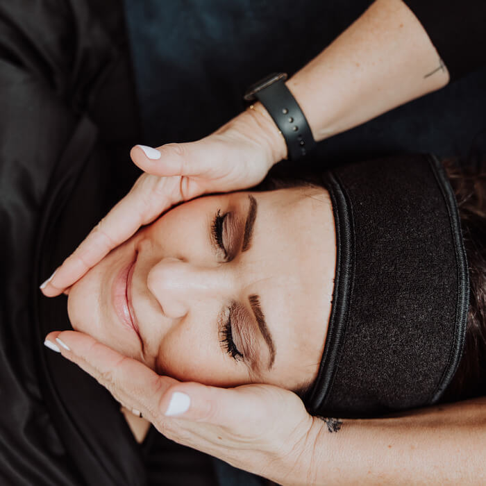 Woman happy with gentle hands massage on face | Wellness Co. | Zeeland, MI